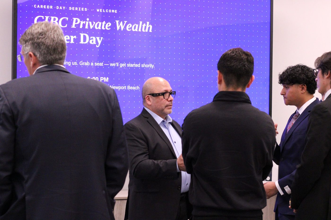 Students and CIBC professionals talk before the program starts